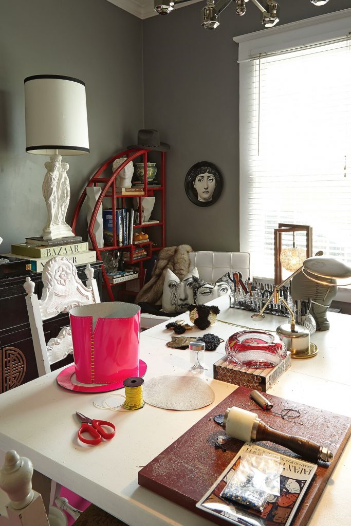 The Dan & Joseph studio is a haven for leather-working tools and hats in progress. Vintage finds mix with a Fornasetti plate and pillows.