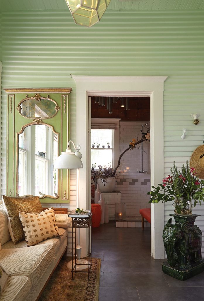 in a hallway leading to the studio, the 19th-century French mirror is a estate-sale find. One of a pair of elephant urns, which were brought back by Steffen's grandfather from India.