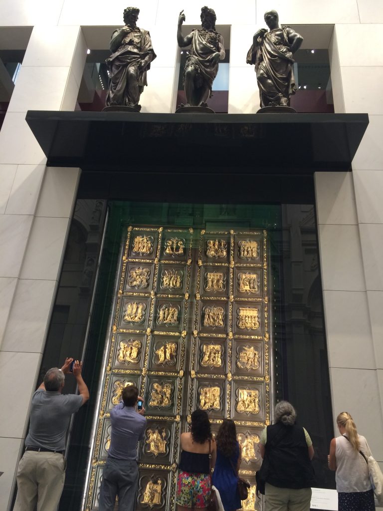 Tourists photograph Ghiberti's original Door of Paradise in the Duomo Museum.