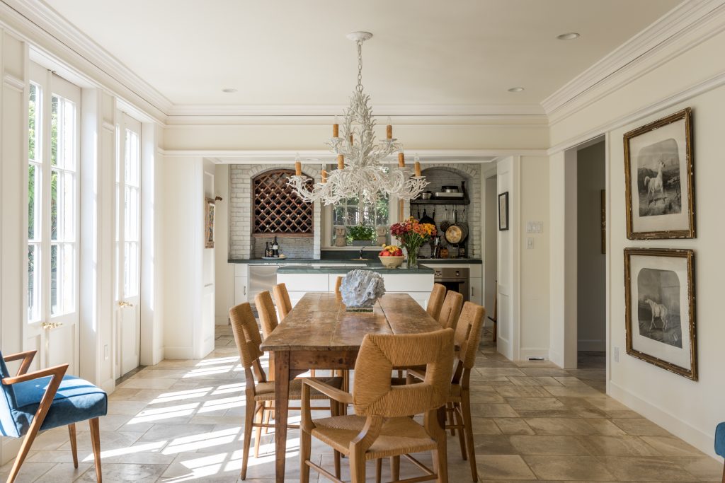 In the dining room, a metal faux-coral chandelier and antique French table, both from Mecox. Blue-coral centerpiece. Custom woven-rope dining chairs. Antique equine prints.