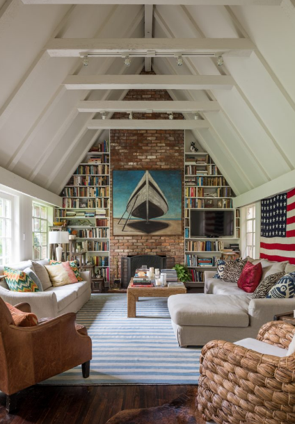 (8) In the cottage living room is the couple's book collection. Painting by Hamptons-based artist Terry Elkins. Custom sofa and sectional in Belgian linen, early Christopher Spitzmiller lamp, rug, and coffee table, all from Mecox.