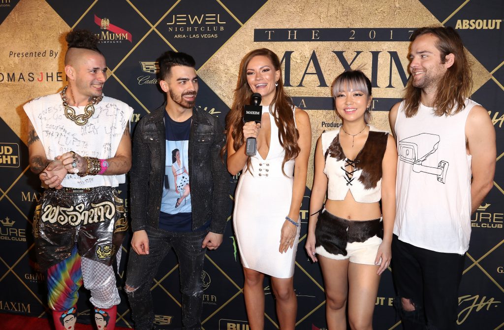 HOUSTON, TX - FEBRUARY 04:  Model Caitlin O'Connor (C) interviews musicians (L-R) Cole Whittle, Joe Jonas, JinJoo Lee, and Jack Lawless of DNCE at the Maxim Super Bowl Party on February 4, 2017 in Houston, Texas.  (Photo by John Parra/Getty Images for Maxim)