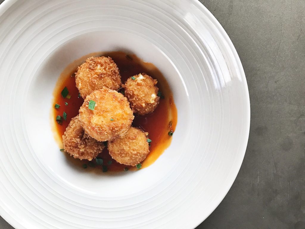 Pimento cheese fritters at Field & Tides are stuffed with local sharp cheddar and served with pepper jelly. (Photo by Jailyn Marcel) 