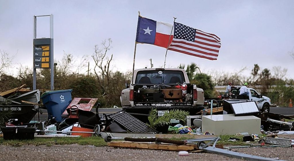 The Texas flag flies alongside the American flag amidst Hurricane Harvey's destruction. 