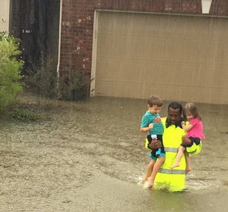 A man rescuing two children from rising flood waters — a photo that has now gone viral via social media. 