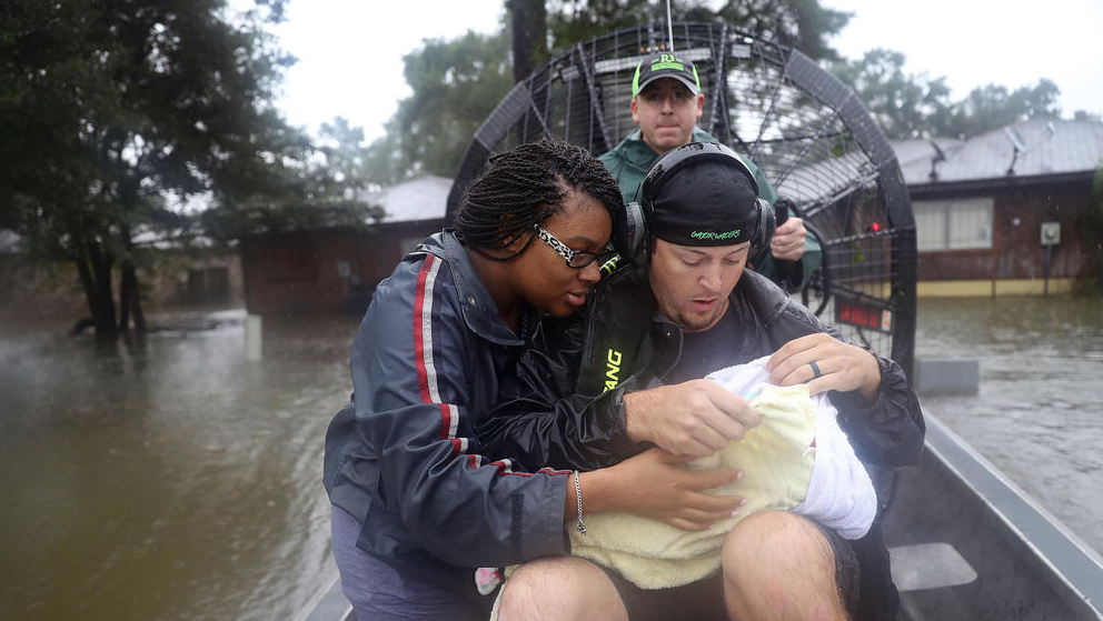 Dean Mize and Jason Legnon rescue Shardea Harrison and her three-week-old baby in their airboat. (Photo by Joe Raedle / Getty Images) 