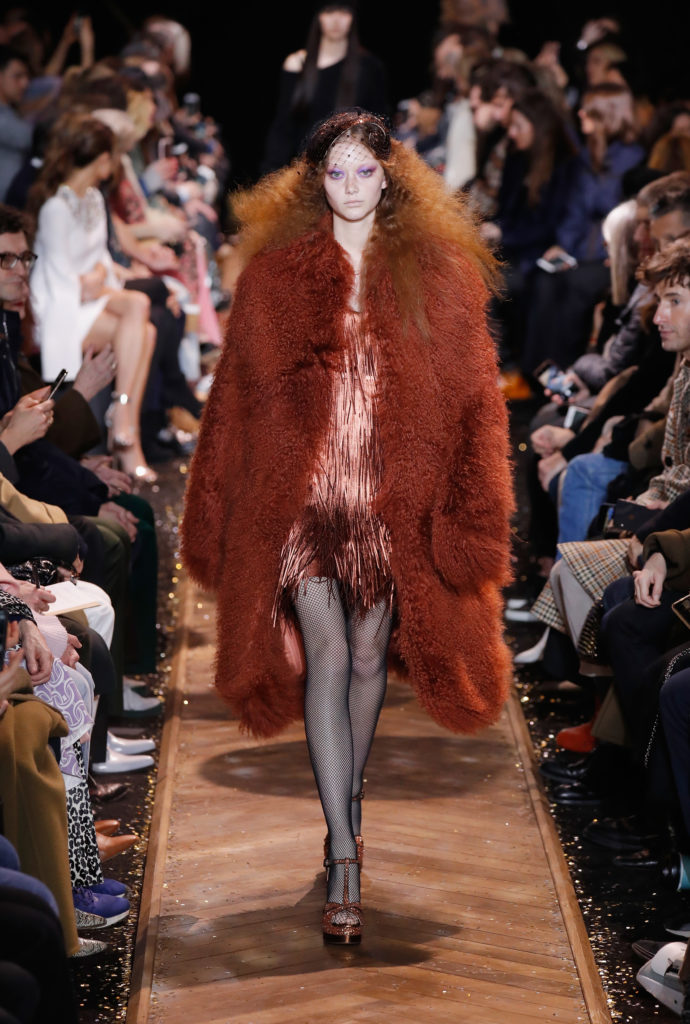 Model Sara Grace Wallerstedt walks the runway in a Michael Kors Collection metallic orange mini-dress and fur. (Photo by JP Yim/Getty Images for Michael Kors)