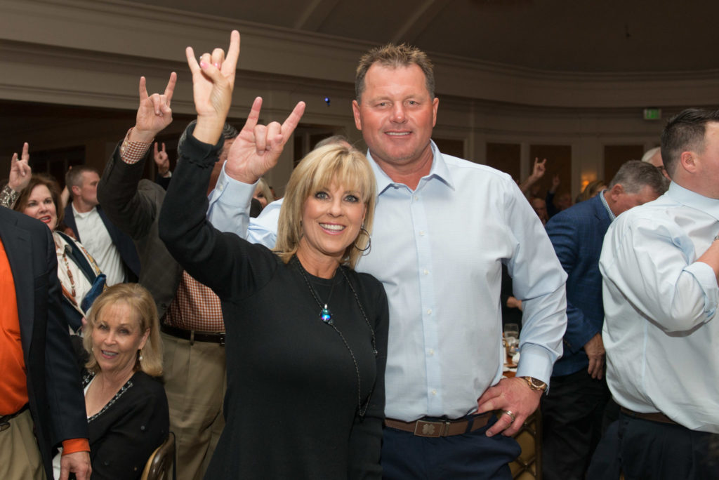 Debbie and Roger Clemens standing Hook ’em Horns (Photo by Jacob Power)