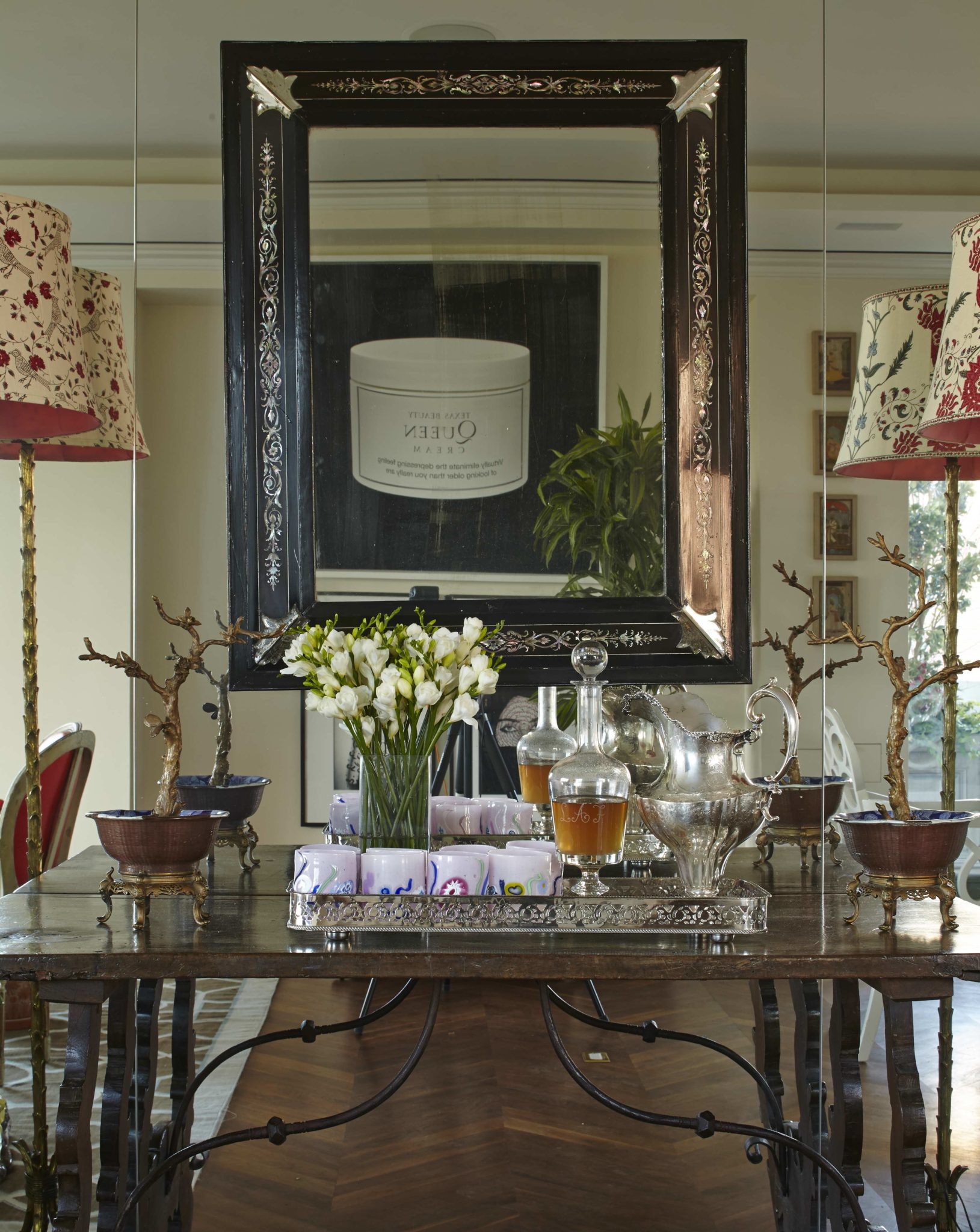 Antique table from Nick Brock Antiques holds Laguna B glassware from Venice. Venetian mirror reflects a painting by Houston-born artist Rachel Lee Hovnanian.