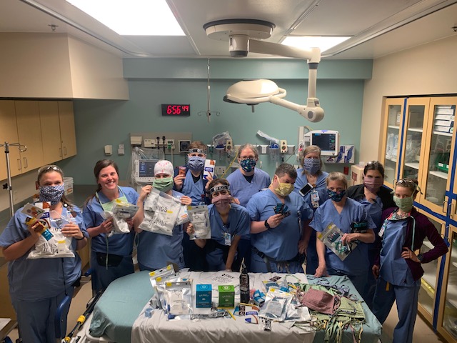 Hospital workers gather to unbox new masks made by refugee women