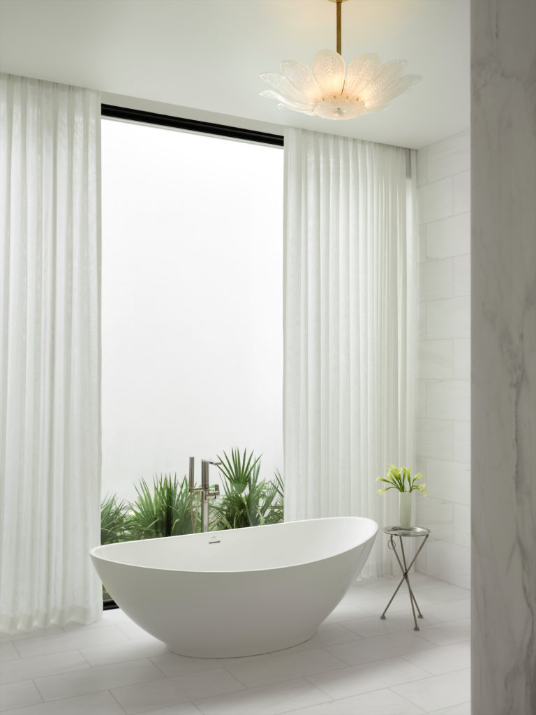 The main bathroom's tub and fittings are from Elegant Editions. Light fixture from John Gregory Studio.  (Photo by Lisa Petrole)