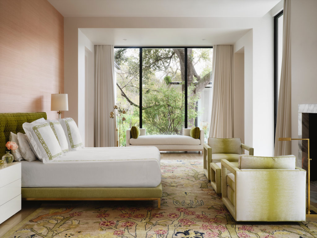 The main bedroom's palette was pulled from the vintage rug from the homeowner's parents. Elitis wallpaper and Hamburg House linens, both from George Cameron Nash. Custom bed and daybed. Chairs are based on a vintage design and covered in Romo fabric. Vintage mid-century floor lamp by window from Twelve Twenty. (Photo by Lisa Petrole)