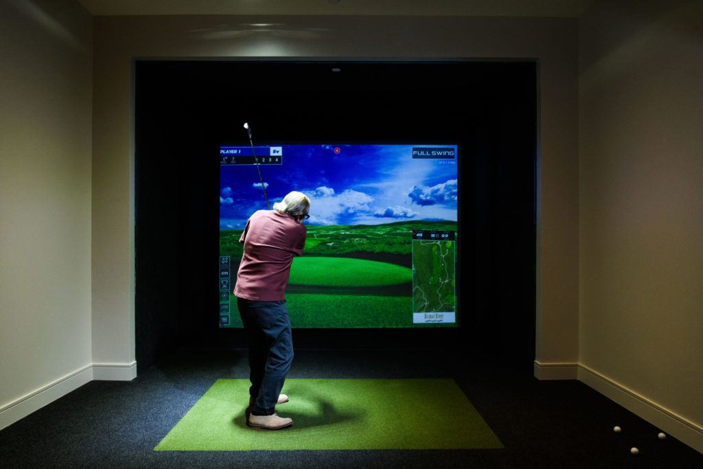 Amenities like a golf simulator aren't just for residents of The Watermark at Houston Heights. They are about making sure your kids and grandkids want to visit too. (Photo by Heather Durham Photography)