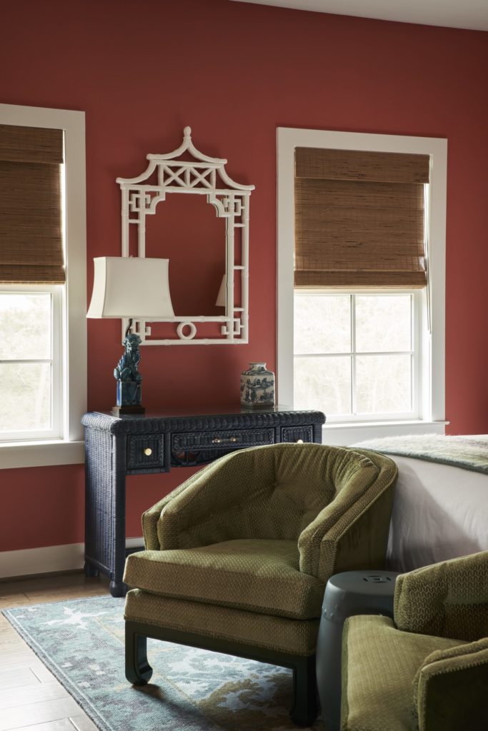 In a bedroom, wicker desk from 209th Designs, Tomball, lacquered navy. Pagoda mirror from Birch Lane. Foo dog lamp is an estate sale find. (Photo by Pär Bengtsson)