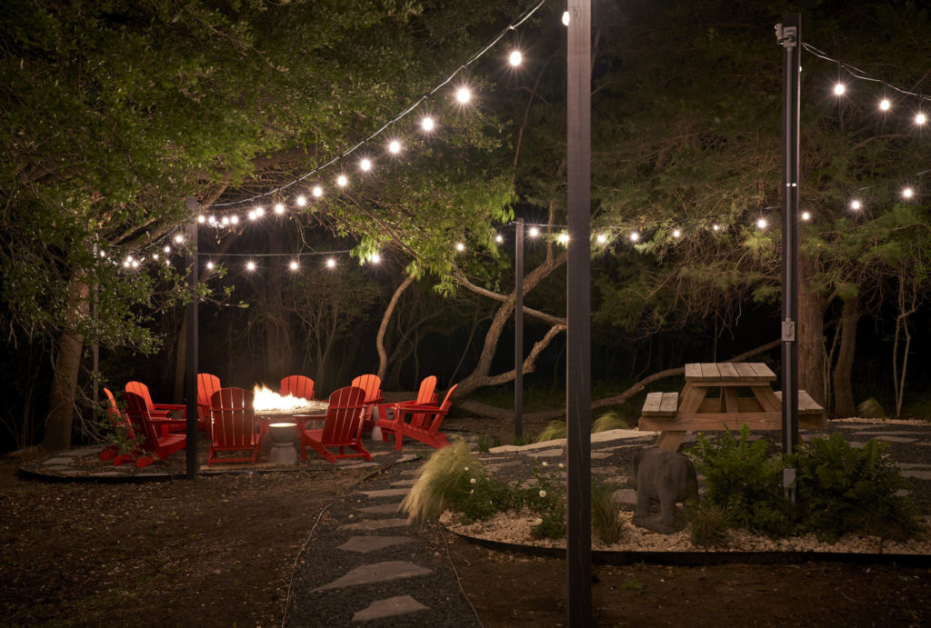 The fire pit with red Adirondack chairs made from bent willow branches by Rick Pratt of Around the Bend. (Photo by Pär Bengtsson)