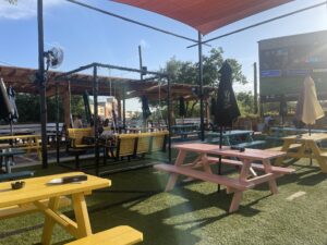 Porch swings and picnic tables dot the turf. And the colorful, kitschy picnic tables have umbrellas for shade at Moonshine Deck in The Woodlands.