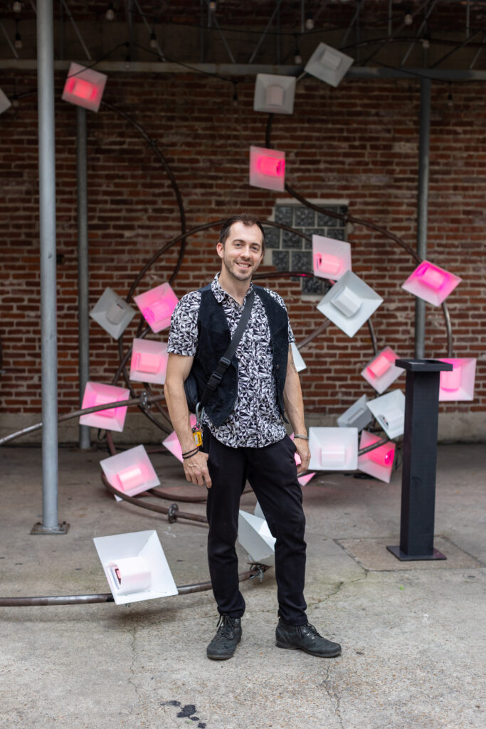 Boston Kassidy of Moon Papas Art in front of the group's interactive sculpture at the 2024 Glasstire Party and Auction (Photo by Jenny Antill) 