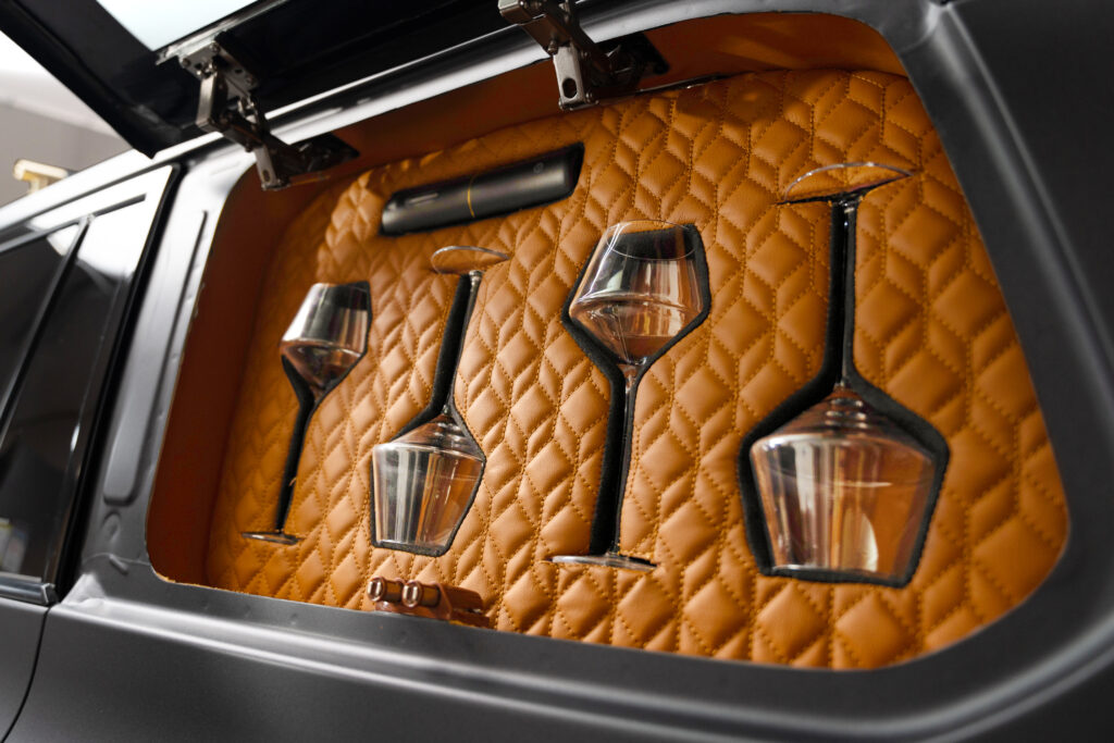 Open the exterior side panel in the Lexus Monogram GX to reveal the ingenious custom storage for your stemware.