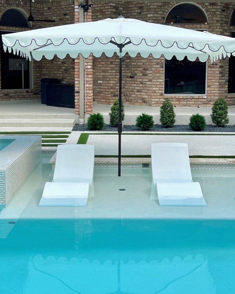 Two scalloped Wayfair umbrellas cover in-pool lounge chairs.