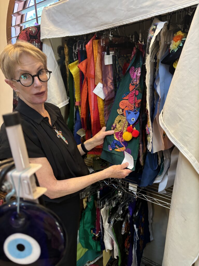Susan Hollingsworth with her art panels, ready to be added to a SuKaz jacket. (Photo by Laura Landsbaum)