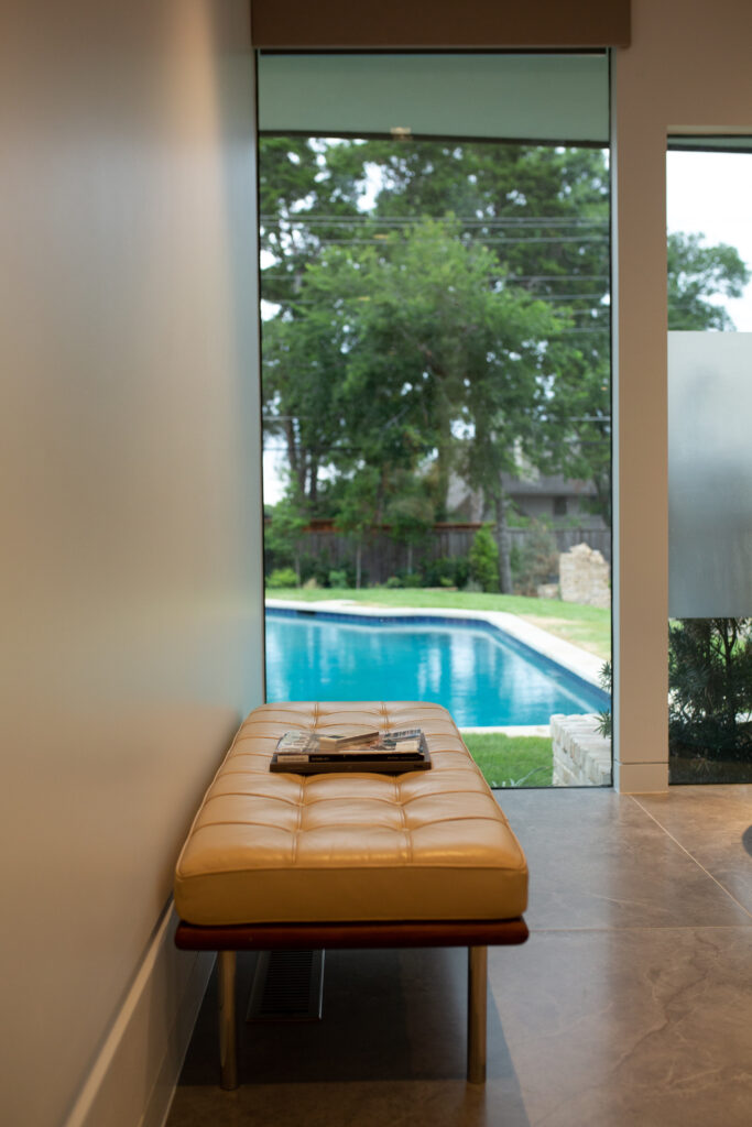 Upon entering the Yemeni home, guests immediately see the entire backyard through massive sections of glass, punctuated by the beautiful terrazzo floors and the breathtaking masonry at the existing fireplace. 