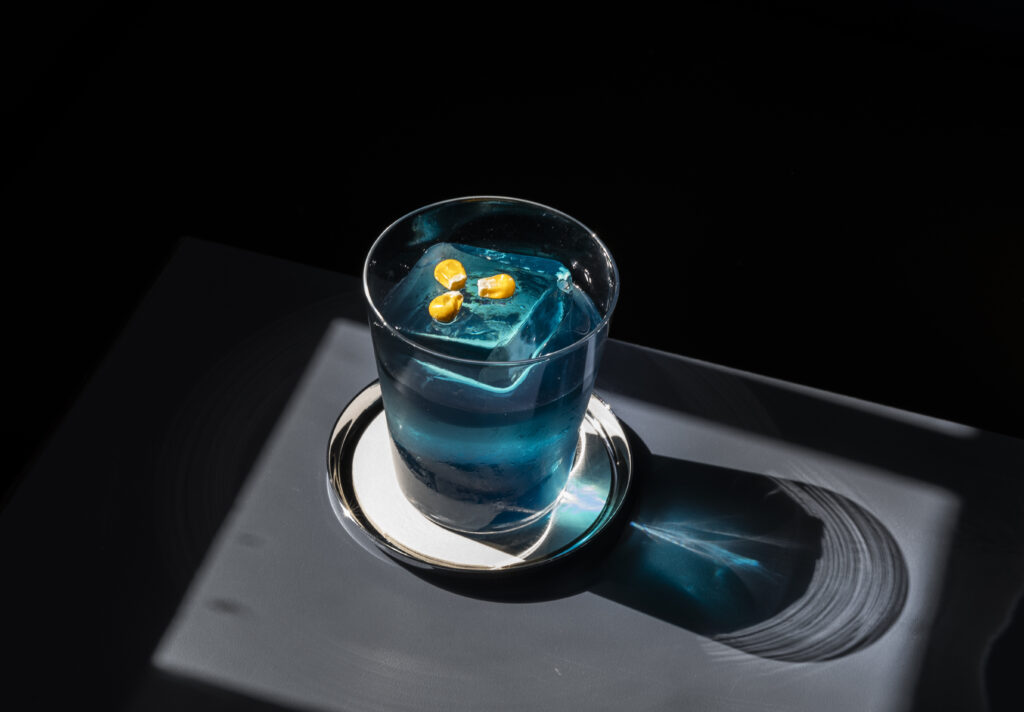 The Pale Blue Eyes cocktail is an azure-hued old-fashioned, with blue-corn bourbon and bitters topped with an oversized square ice cube embossed with “Lee’s," the apostrophe formed by a corn kernel. (Photo by Julie Soefer)
