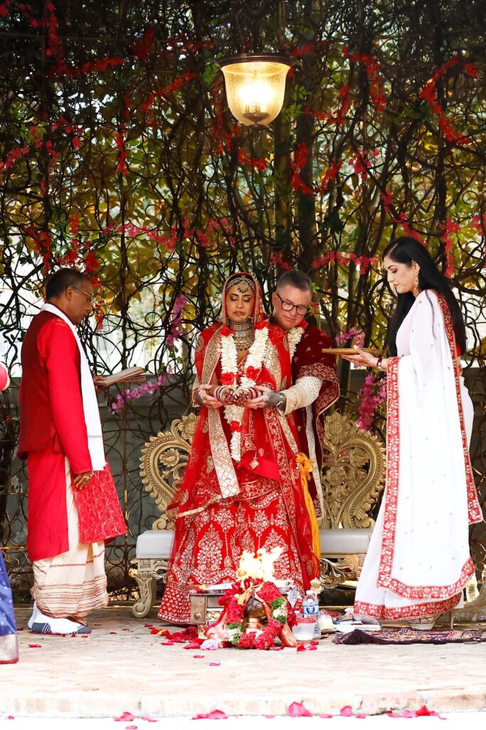 Ruchi Mukherjee & Walter Sassard were wed in a traditional Indian ceremony at The Bryan Museum in Galveston. Dr. Sippi Khurana assists.(Photo by Quy Tran)