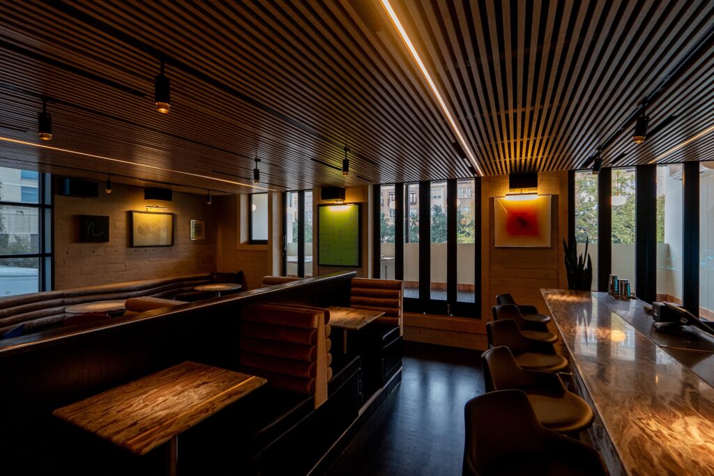 Brittany Vaughan of Garnish Design reimagined Lee's with chrome-accented ebony-colored wainscotting, soft black leather accents, gray velvet and directional lighting. (Photo by Carla Gomez)