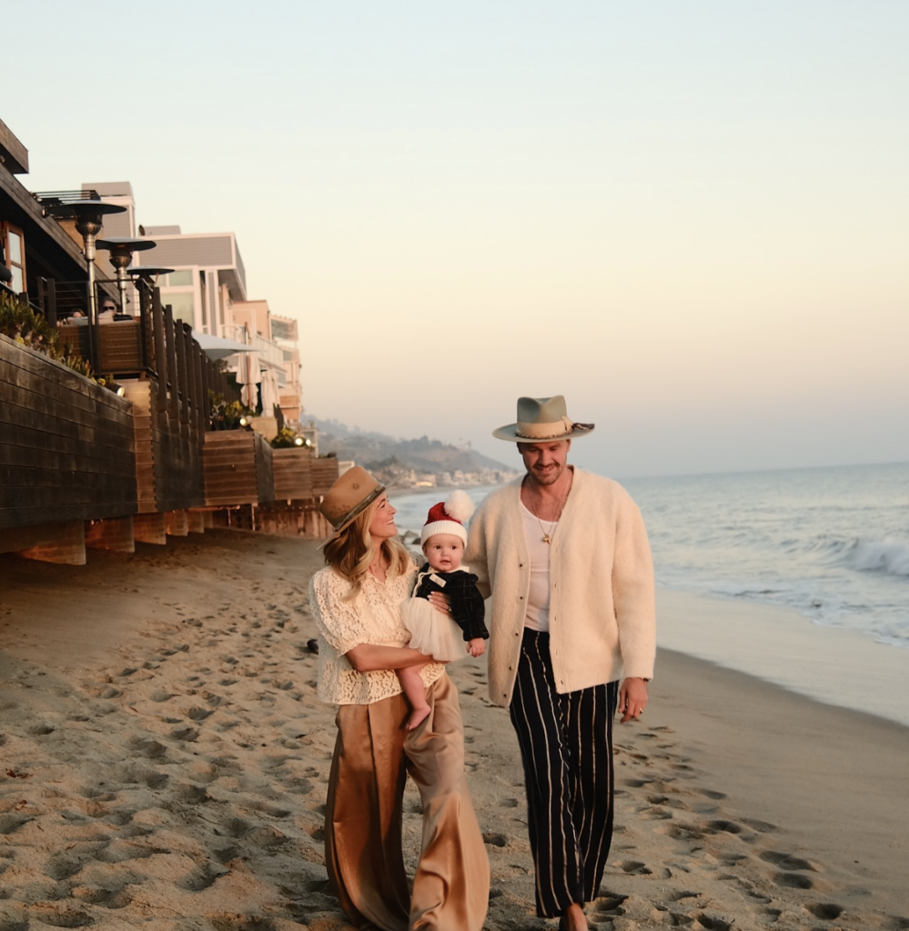 Teressa Foglia & Ty Hays stroll the beaches of Malibu with their baby before the fires destroyed the area. (Instagram photo)
