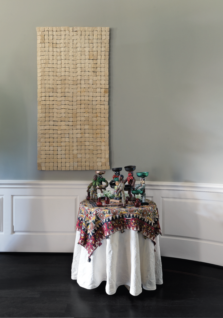 Marilyn Oshman's eye: University of Houston sculpture department chairman Paul Kittleson's droll cracker curtain, in a tête-à-tête with circa-1930s tramp-art men formed from bottle caps, resting atop a table topped by an Afghan embroidery scored from a New York flea market. (Photo by Jack Thompson)