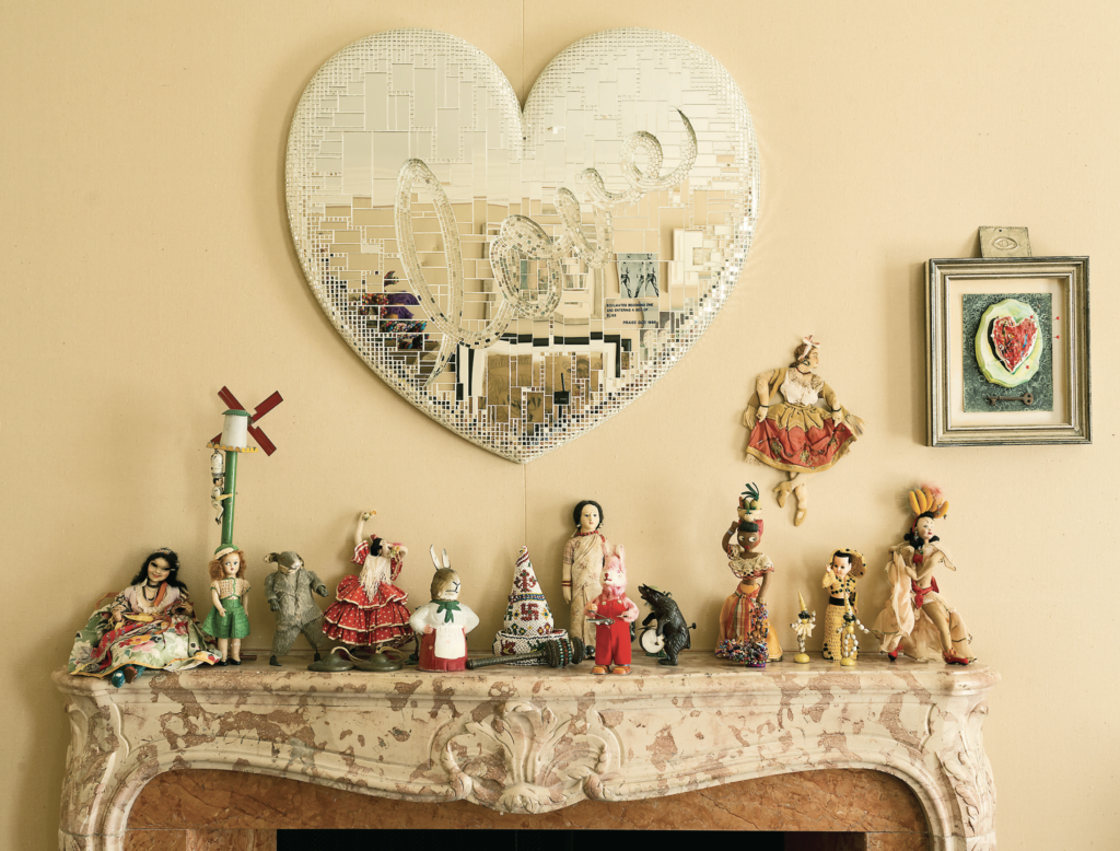 Marilyn Oshman house: Over a rococo-style fireplace, Forrest Prince's mirror work proclaims “Love,“ while an array of vintage dolls look on.
(Photo by Jack Thompson)