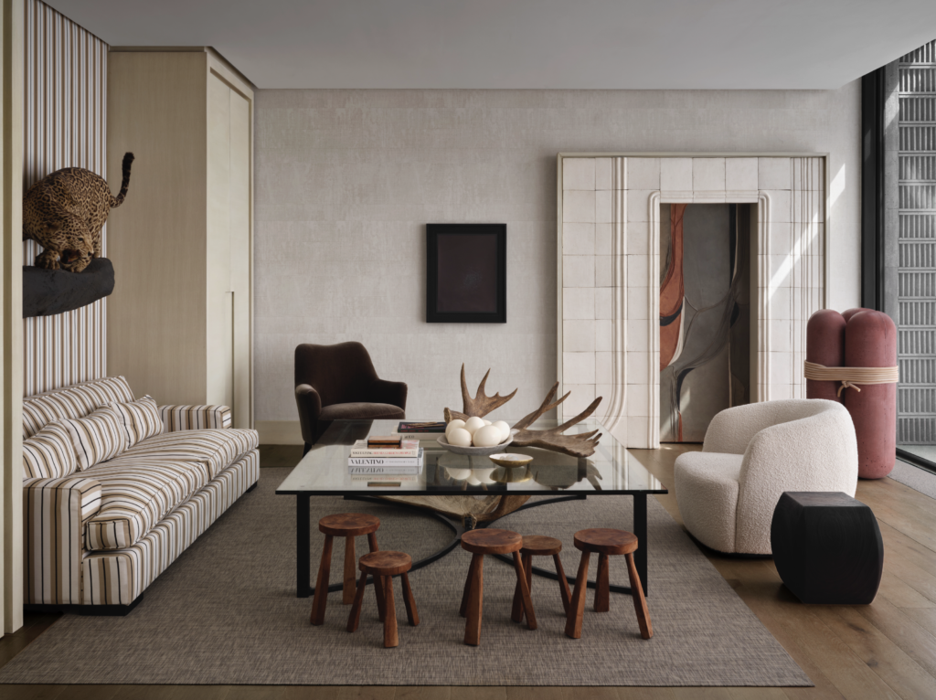 In a seating area, a Modénature sofa and wall are covered in Perennials Bedouin stripe. Taxidermy mount is a hunting trophy from Mauricio Lobeira’s father. Modénature velvet armchair, coffee table by Ten Plus Three. CB2 bouclé chair and Muricate side table. Stools are a street find. (Photo by Douglas Friedman)