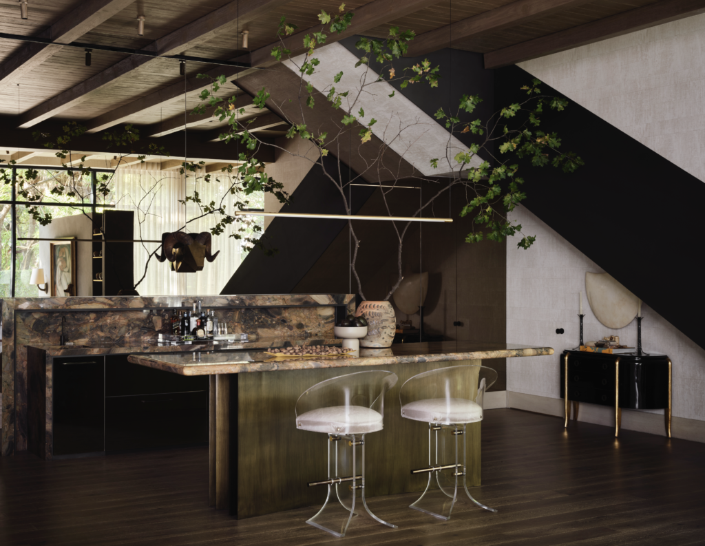 The bar’s mix of rich materials with marble counters, bronze kick-plate, rustic beams, a brown mirrored wall, and vintage Lucite stools. Lightology pendant. (Photo by Douglas Friedman)