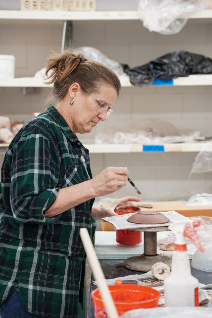 Jennifer Herzberg paints a piece of pottery. (Photo courtesy Empty Bowls Houston)