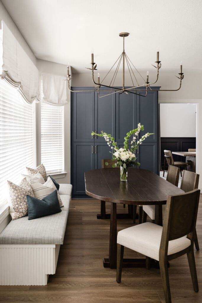 An eleven-foot built-in banquette with hidden storage anchors the dining area, paired with an oval table for everyday use. (Photo by Madeleine Harper)