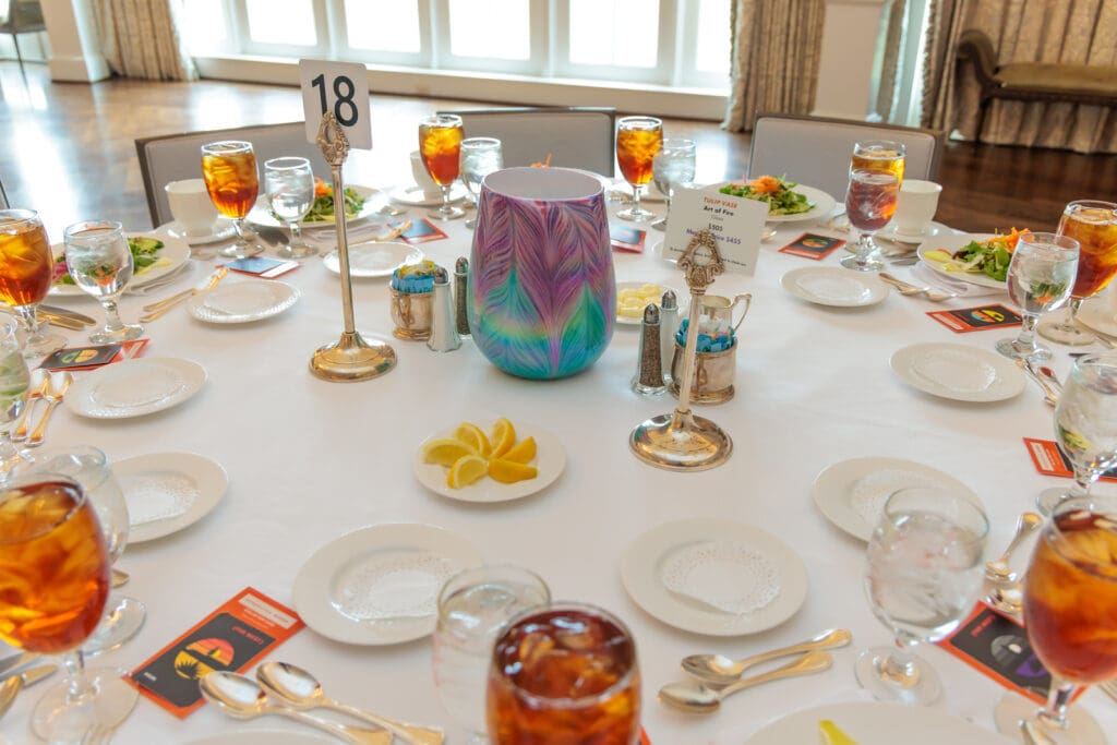 Each table was punctuated by a stunning, collectible centerpiece; shown here, Art of Fire's glass "Tulip Vase." (Photo by Katy Anderson)