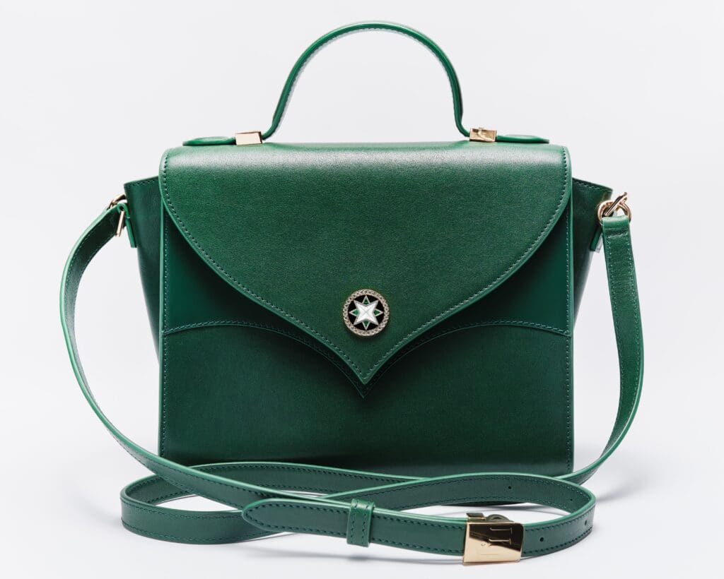 The 11 Juillet Mayfair bag features a top leather handle as well as a long leather strap that can be worn over the shoulder or as a crossbody.