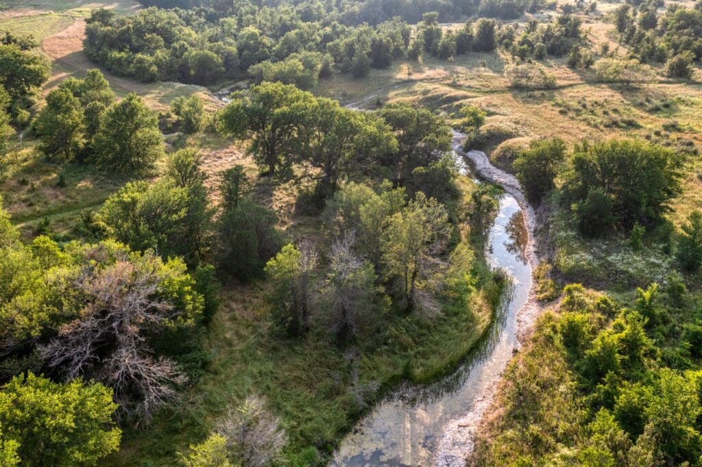 A winding creek cuts through the heart of the Maverick property, offering scenic views and natural gathering spots throughout the 1,100-acre landscape. (Courtesy)
