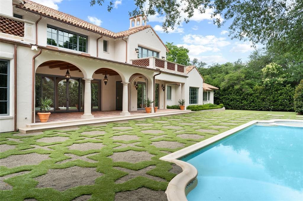 The home sits on nearly one acre of land and features large windows overlooking the pool, lawn, and gardens, accordion glass doors that open to the loggias, and a guest quarters. (Courtesy)