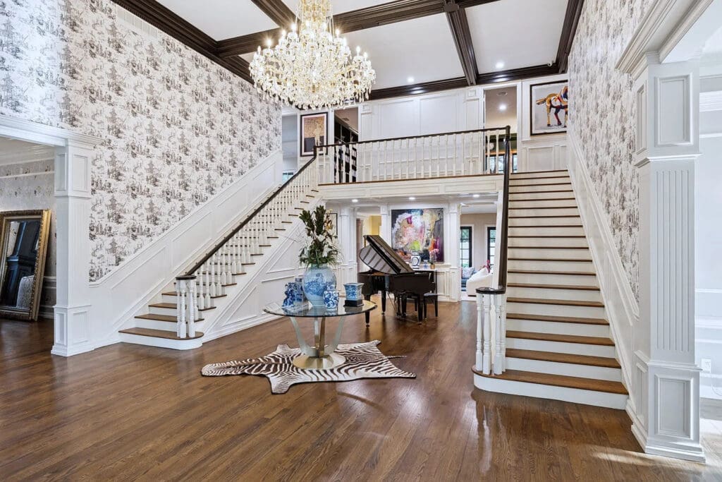 Dual grand staircases, which floor-to-ceiling windows illuminate, in the foyer of 5130 Radbrook Place. (Photo by Allie Beth Allman & Associates)
