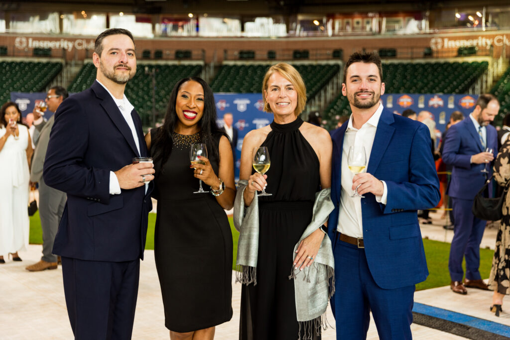  Guests at left join Cheniere Energy's director of global corporate giving Wendy Craven and son Ross Craven at the Houston Astros Foundation Wine Dinner on the field at Daikin Park. 