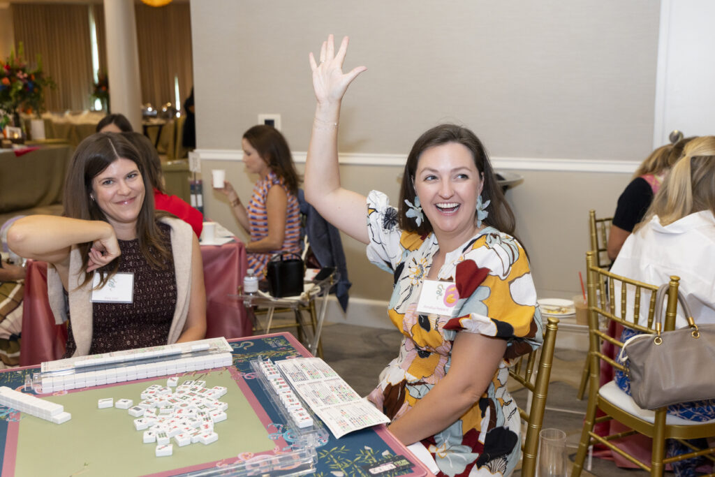 Annalisa Peppard raising her hand for a mahjong win (Photo by Sharon Ellman, Ellman Photography)