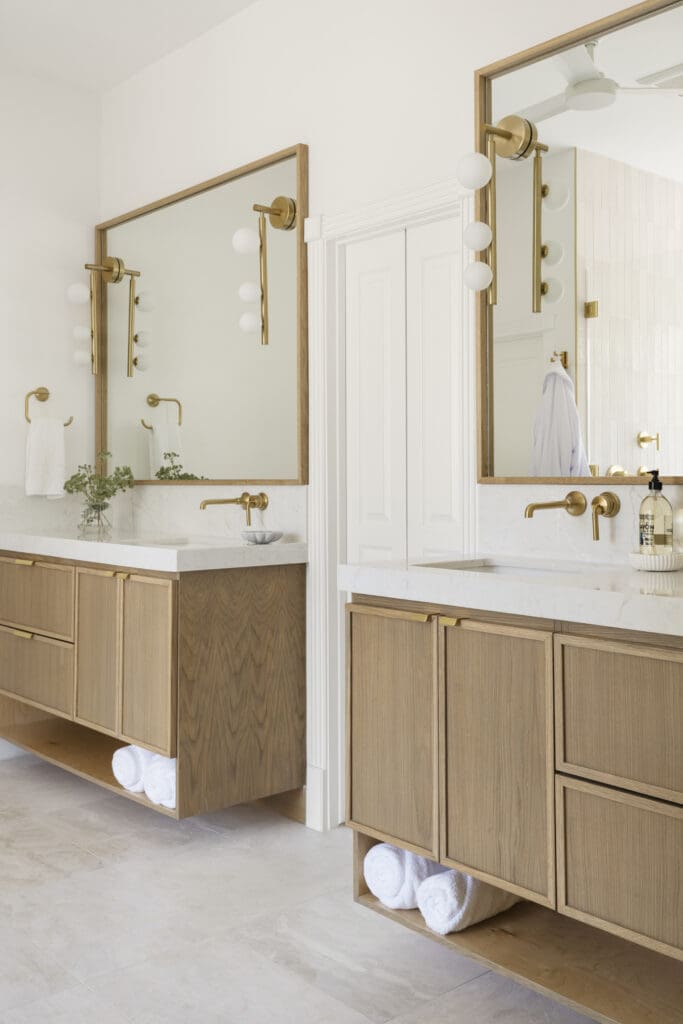 Floating white oak vanities keep the primary bath light and clean.