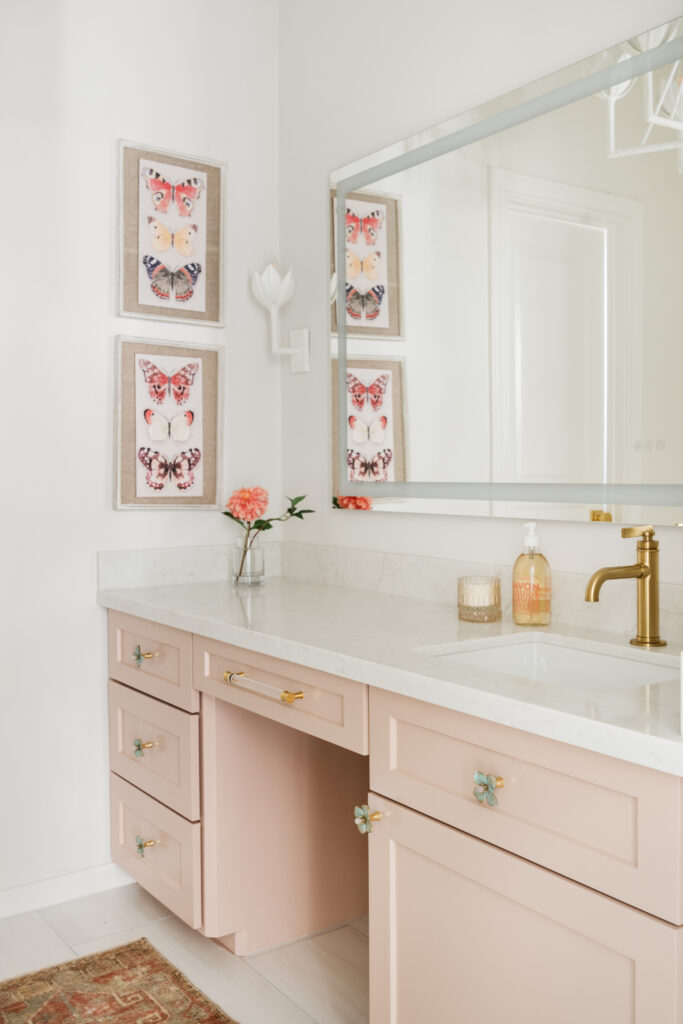 A pink painted vanity with floral drawer pulls makes this bathroom a dream for any girly girl. (Photo by Madeline Harper Photography)