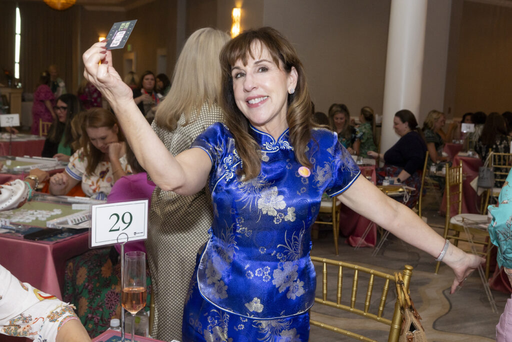 Rebecca Mendel holds up Mahj for Meals punch card after winning a round of mahjong. (Photo by Sharon Ellman, Ellman Photography)
