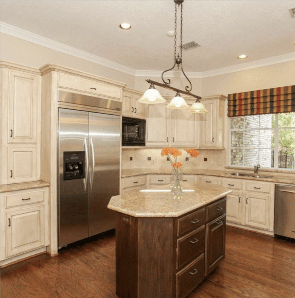 Before Tiny Haven Design’s updates, the dated kitchen had a small island without seating and wooden floors.