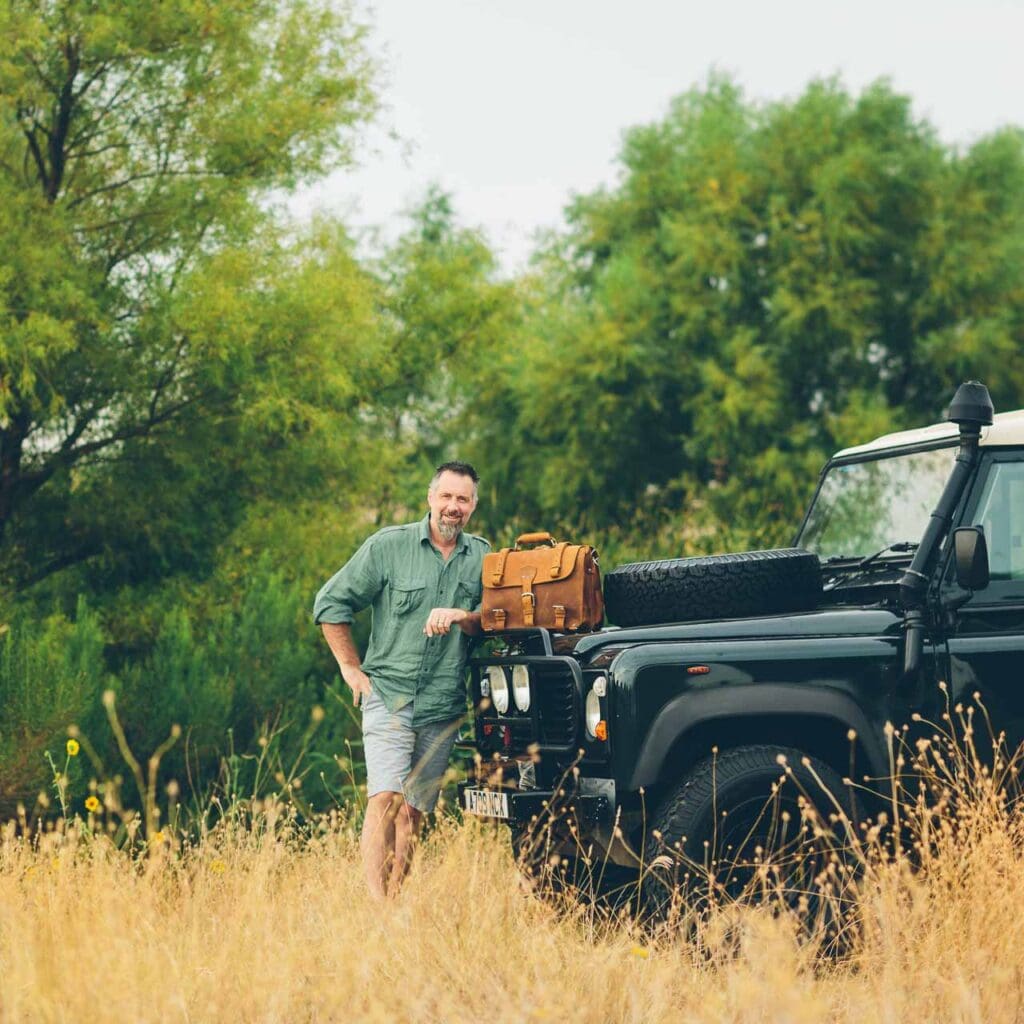 Dave Munson on safari with his well-worn Saddleback bag, a testament to the brand’s rugged durability. (Photo by Saddleback Leather Co. )