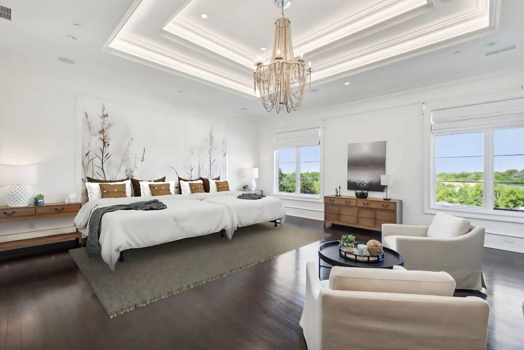 The serene primary bedroom features layered tray ceilings, custom millwork, and panoramic views that extend over the landscaped grounds. (Full Package Media)