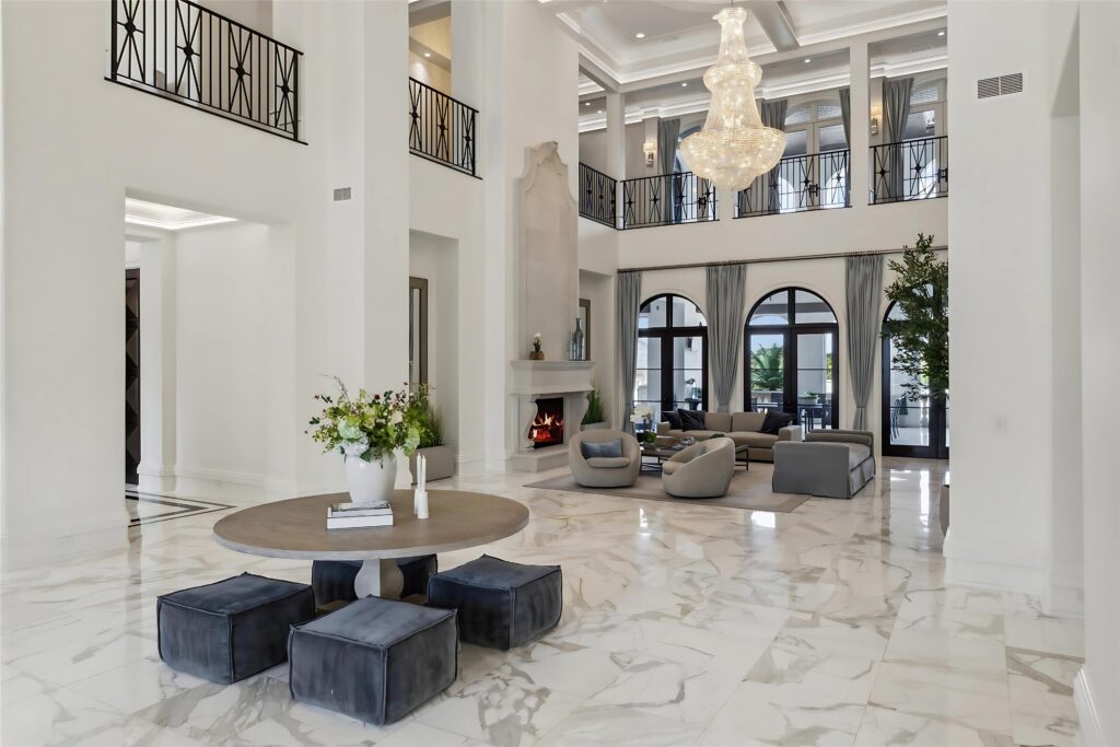 Towering ceilings, marble floors, and arched windows fill the main living space with natural light and symmetry. (Full Package Media)