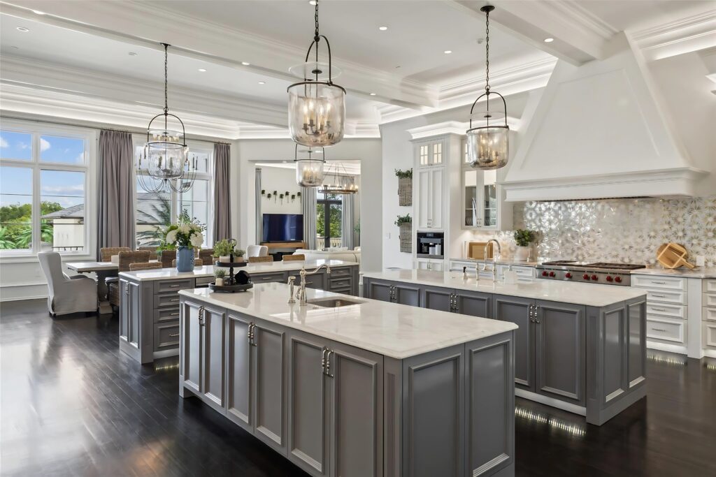 Dual islands, a marble backsplash, and glass-pane pendant lighting define the showpiece kitchen. (Full Package Media)